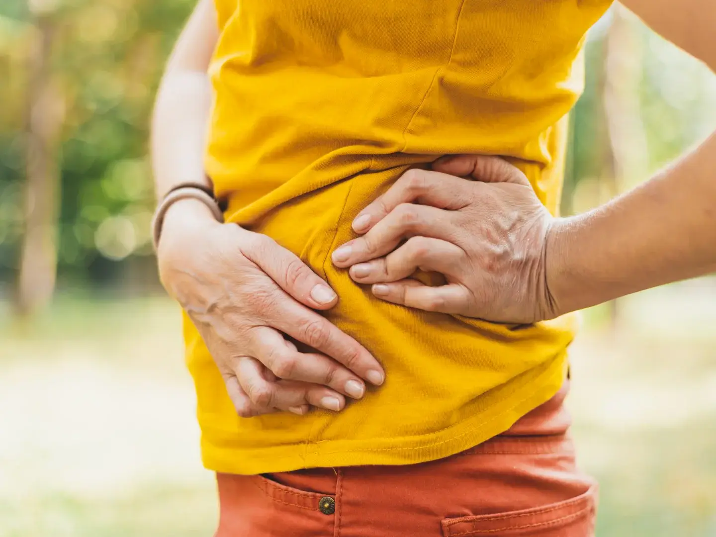 An adult holding the side of their hip